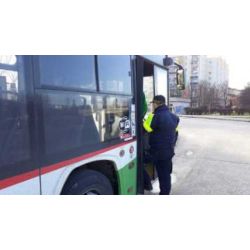 zdjęcie przedstawia strażnika miejskiego stojącego przy autobusie miejskim podejmującego interwencję